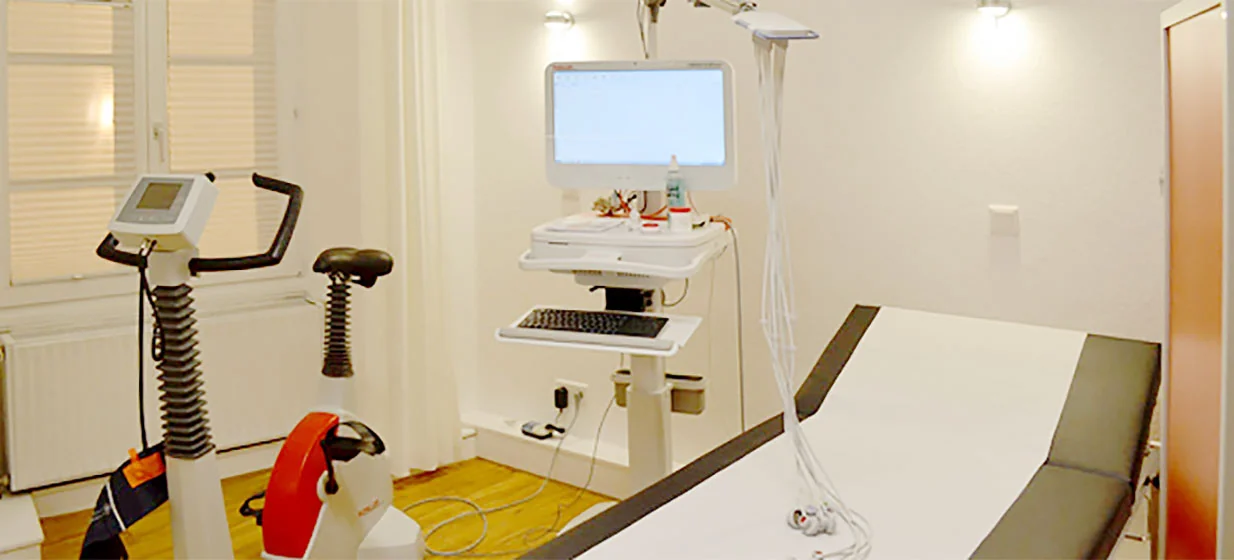 Der EKG-Raum mit Liege und Ergometer am Fenster