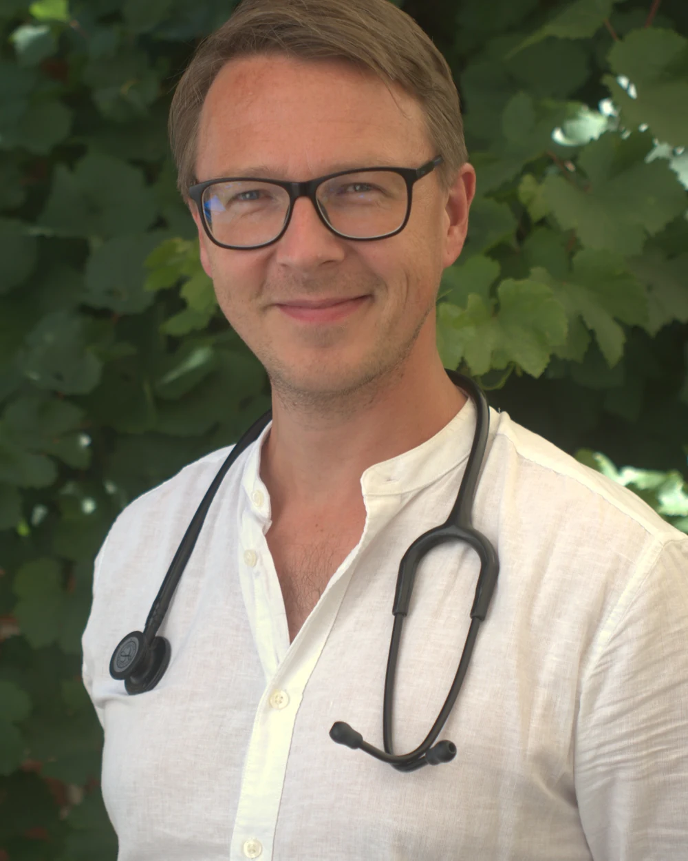 Jens Jütting vor der begrünten Backsteinwand im Hof